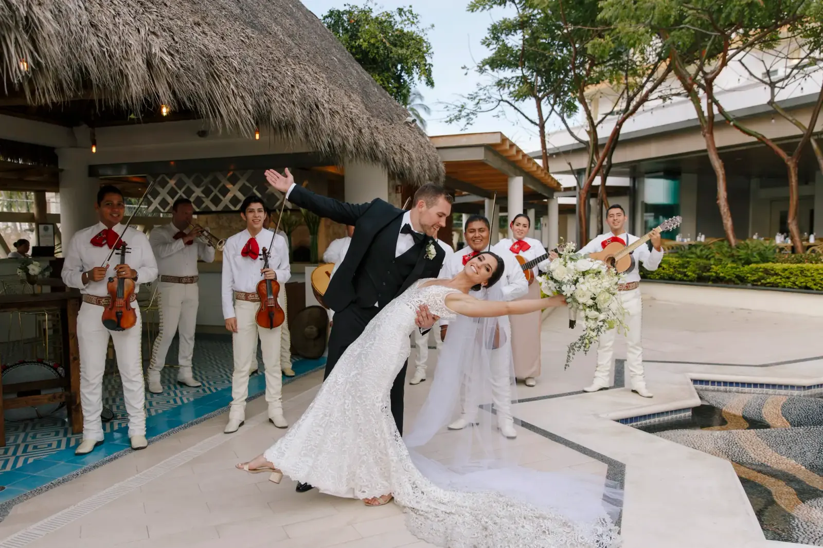 Newlyweds celebrating with a live mariachi band at a Banderas Bay resort by Evgenia Kostiaeva